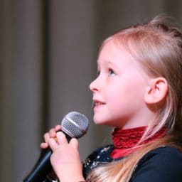 Young girl singing into a microphone