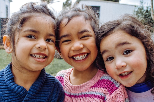 Children with hearing loss three smiling kids
